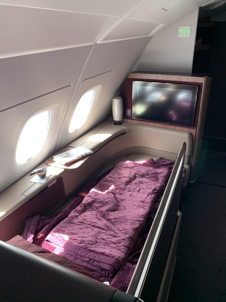 In der First Class von Qatar Airways genießen Passagiere einen erholsamen Schlaf in einem geräumigen und komfortablen Bett.