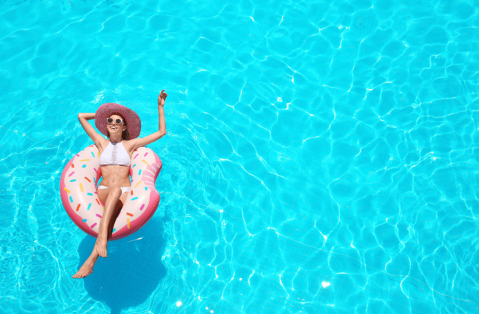 Schöne_junge_Frau_im_Swimmingpool-min 10.000 Punkte pro Aufenthalt bei Radisson – besonders interessant für kurze Trips.