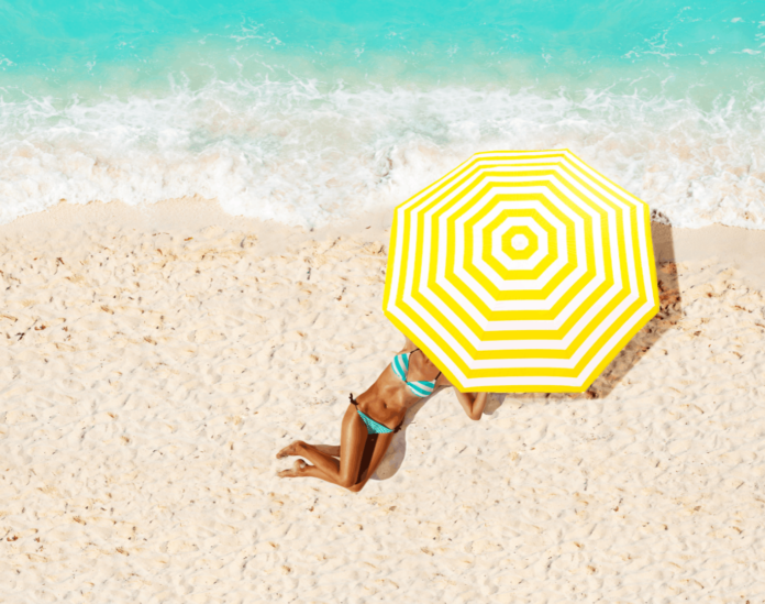 Frau_am_Strand_untereinem_ Sonnenschirm Bis zu 5.000 Marriott Bonvoy Bonuspunkte pro Aufenthalt sichern.