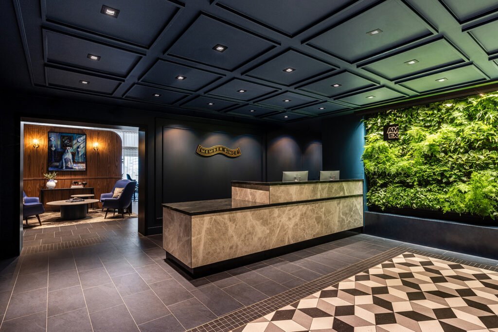 Der Eingangsbereich der neuen Centurion Lounge mit Rezeption und begrünter Wand.