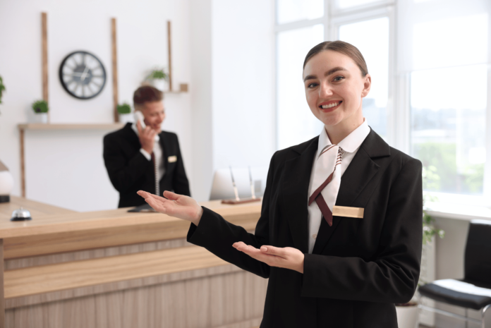 Lächelnde-Rezeptionistin-im-Hotel WorldHotels Rewards: Auch bisherige Punkte und Vorteile sollen erhalten bleiben.